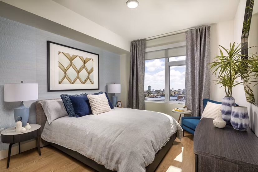 Cozy bedroom with stylish decor and large window in Azul North Park Apartments