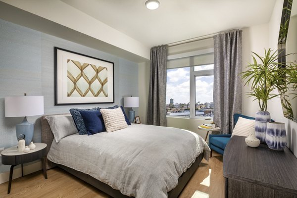 Cozy bedroom with stylish decor and large window in Azul North Park Apartments