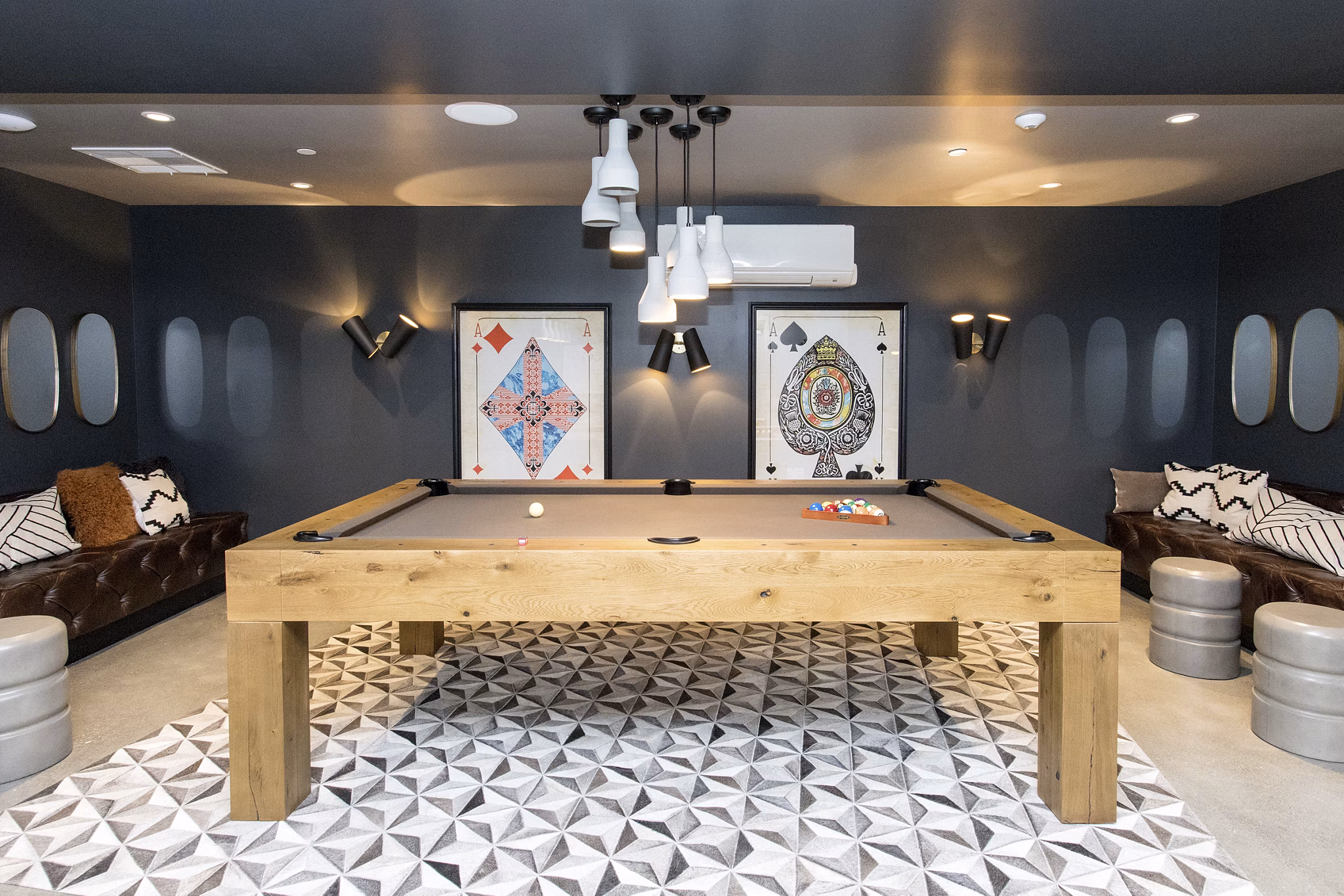 Game room with a pool table, modern lighting, and seating in luxury apartments