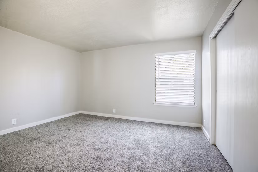Elegant bedroom with plush bedding and large windows in Canoan Village Apartments