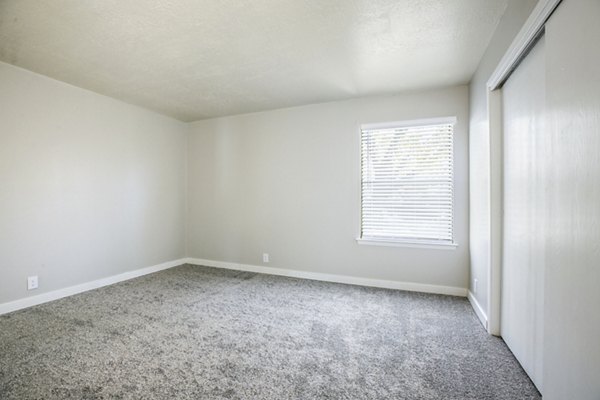 Elegant bedroom with plush bedding and large windows in Canoan Village Apartments