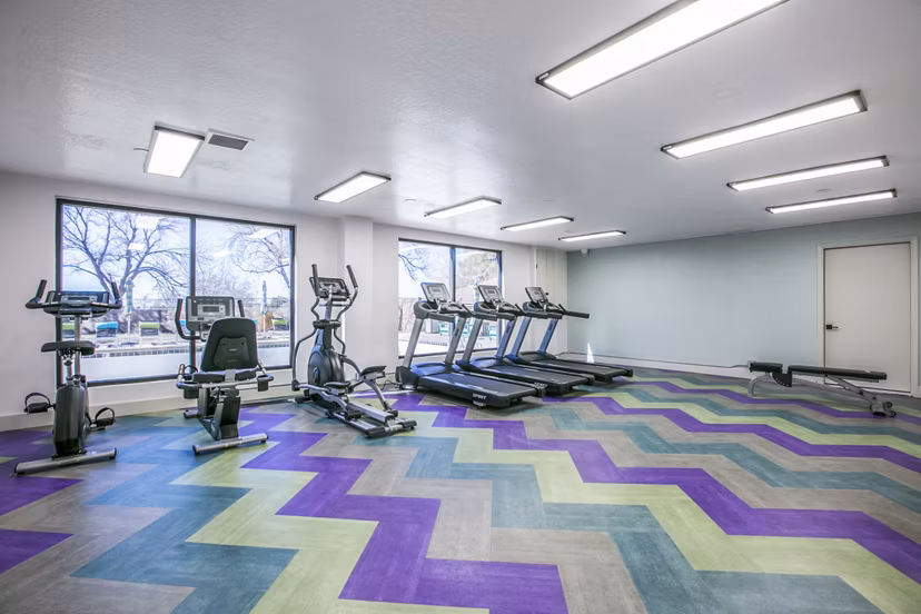 Well-equipped fitness center at Canoan Village Apartments with modern exercise machines and free weights