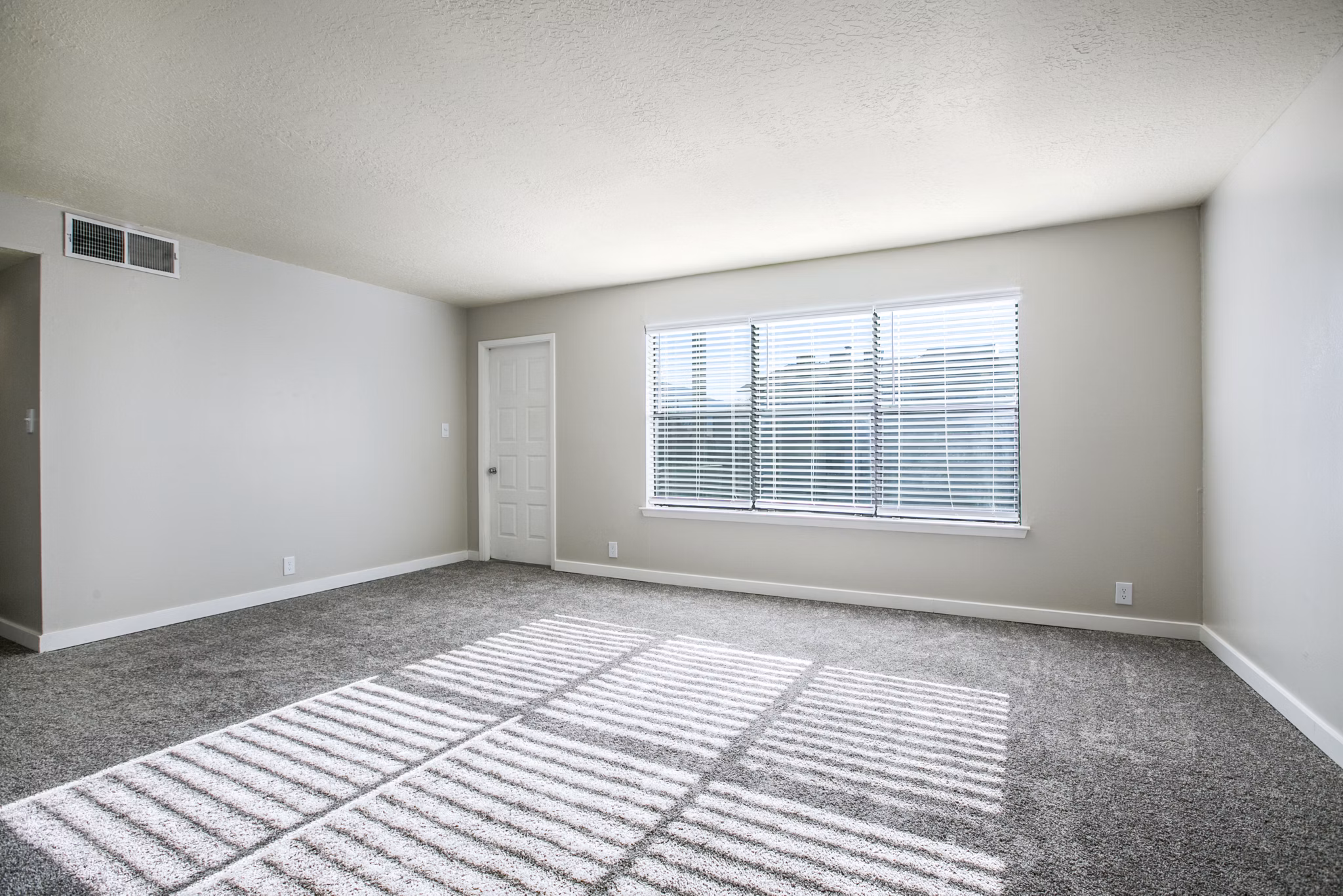 Modern living room featuring sleek decor and large windows in Canoan Village Apartments