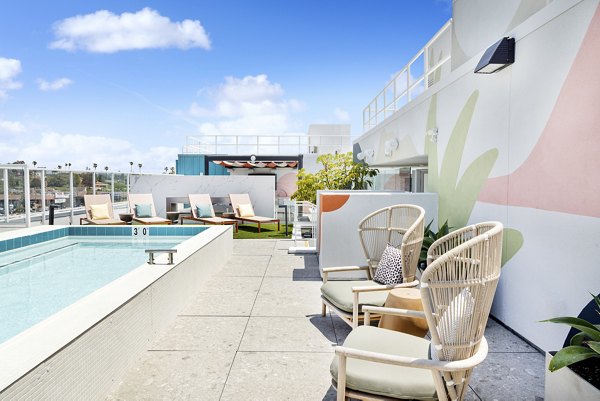Stunning pool area at The Charlie Mar Vista Apartments with lounge seating and lush landscaping
