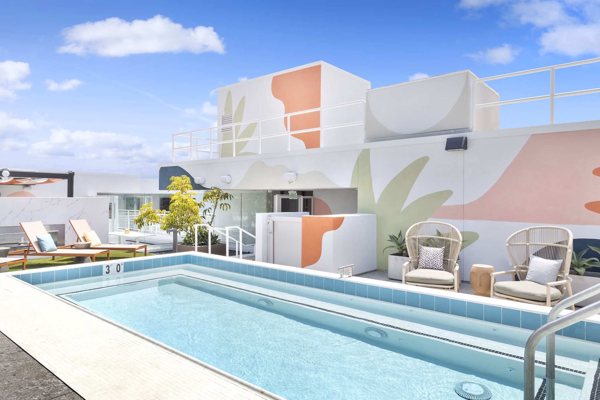 Resort-style pool with chic lounge chairs at The Charlie Mar Vista Apartments, offering luxury leisure amenities in vibrant Los Angeles