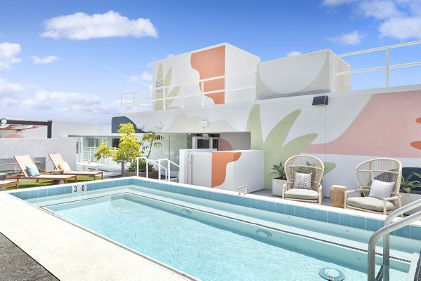 Resort-style pool with chic lounge chairs at The Charlie Mar Vista Apartments, offering luxury leisure amenities in vibrant Los Angeles