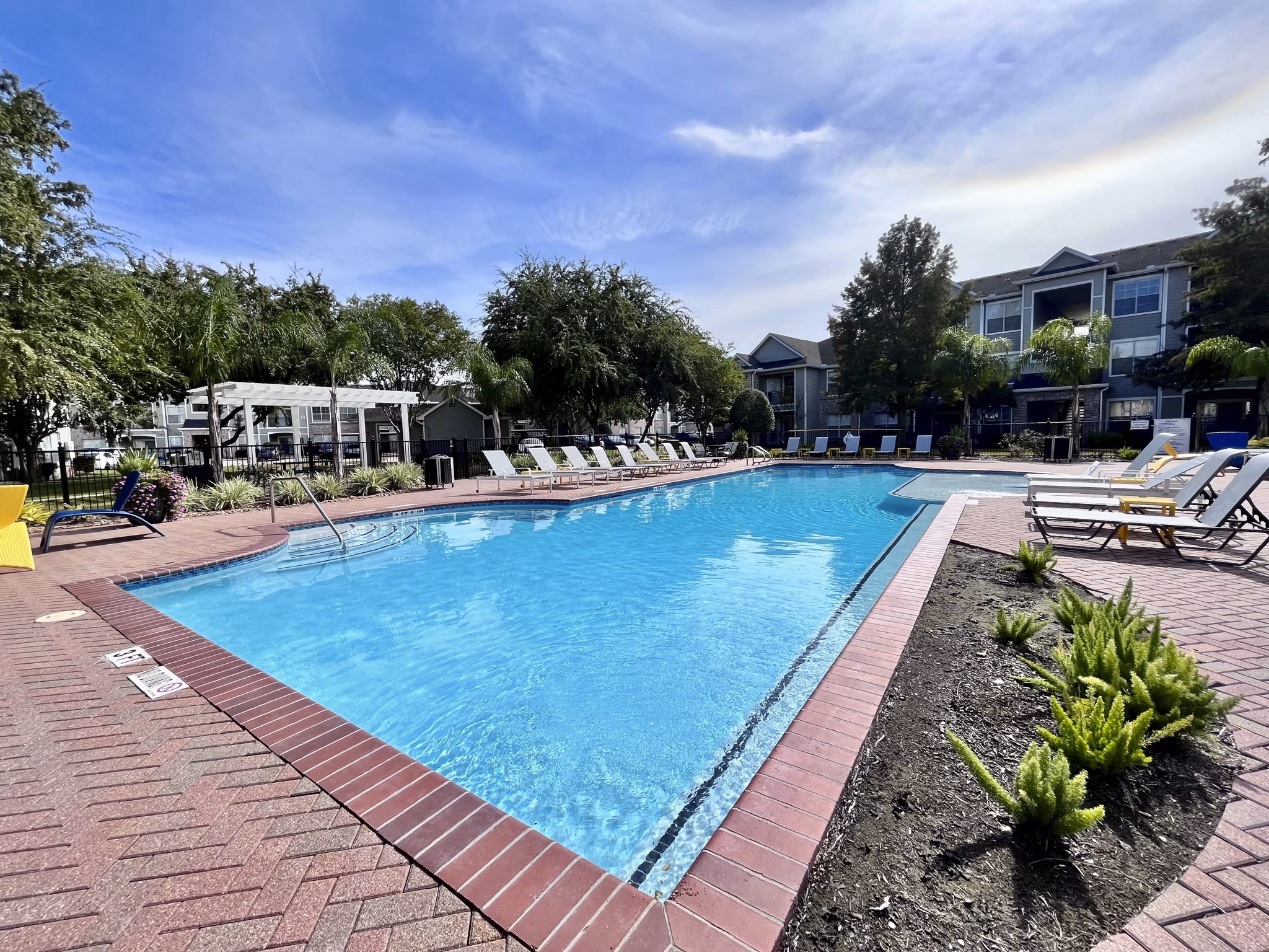 Elegant outdoor pool area at Mirabella Apartments featuring luxurious lounging spaces
