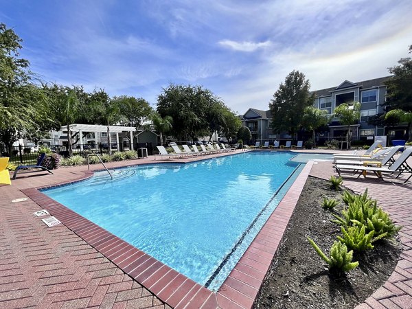 Elegant outdoor pool area at Mirabella Apartments featuring luxurious lounging spaces