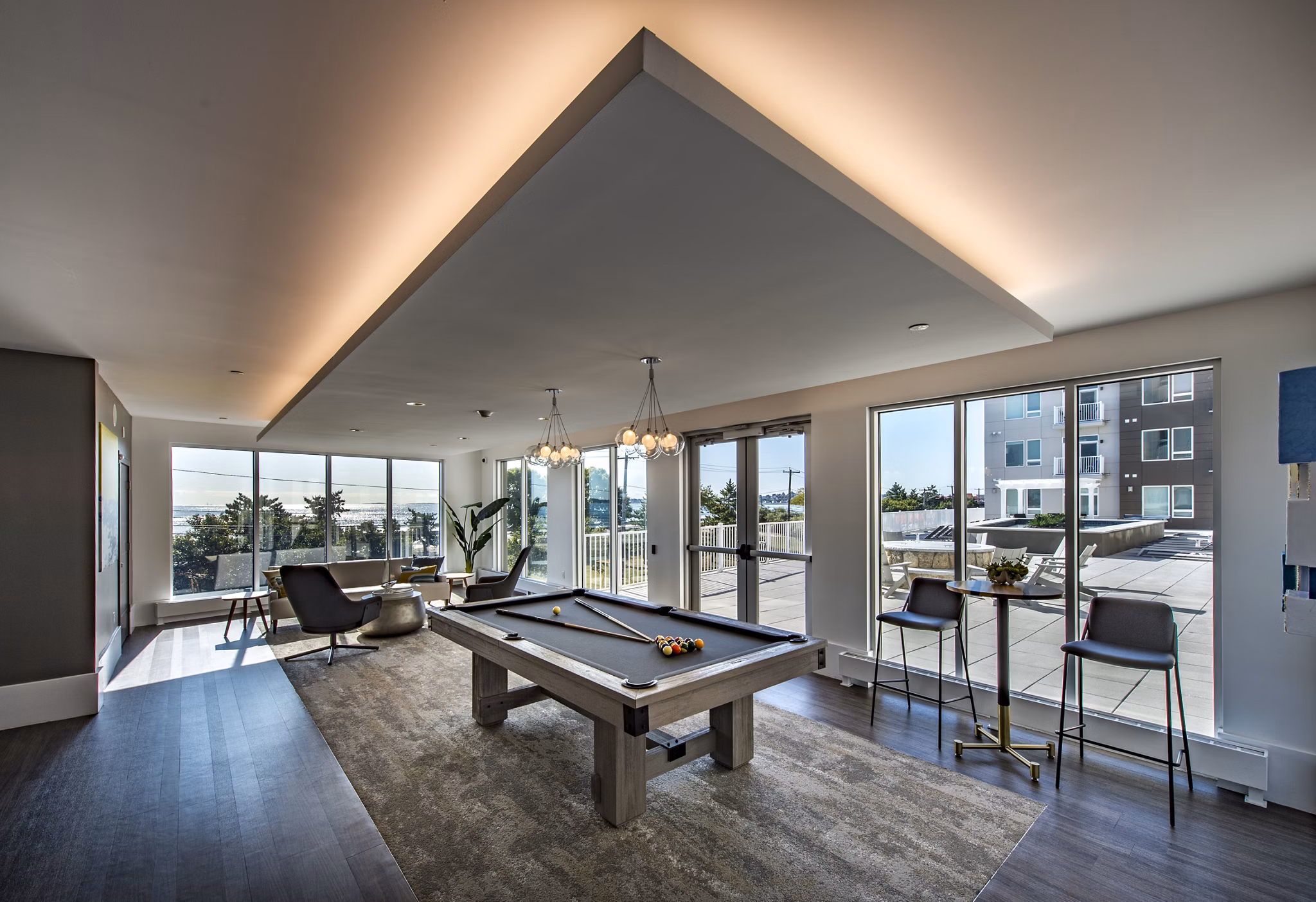 Modern game room with a pool table and cozy seating in luxury apartments