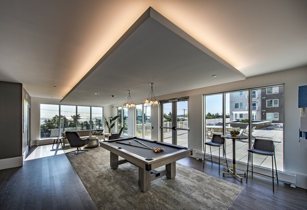 Modern game room with a pool table and cozy seating in luxury apartments