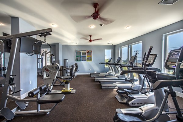 Fitness center featuring modern equipment like treadmills and weight machines in luxury apartments