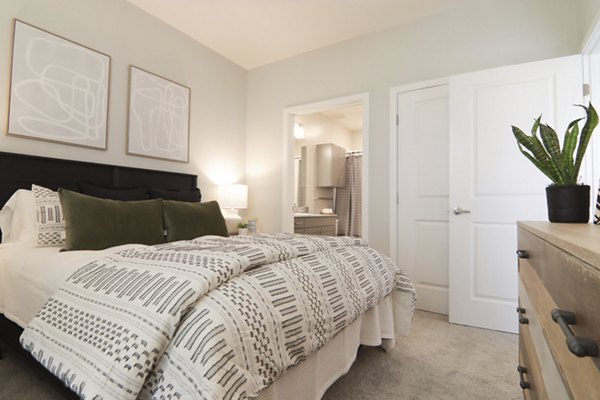 Contemporary bedroom with stylish decor at The Ravelle at Ridgeview Apartments