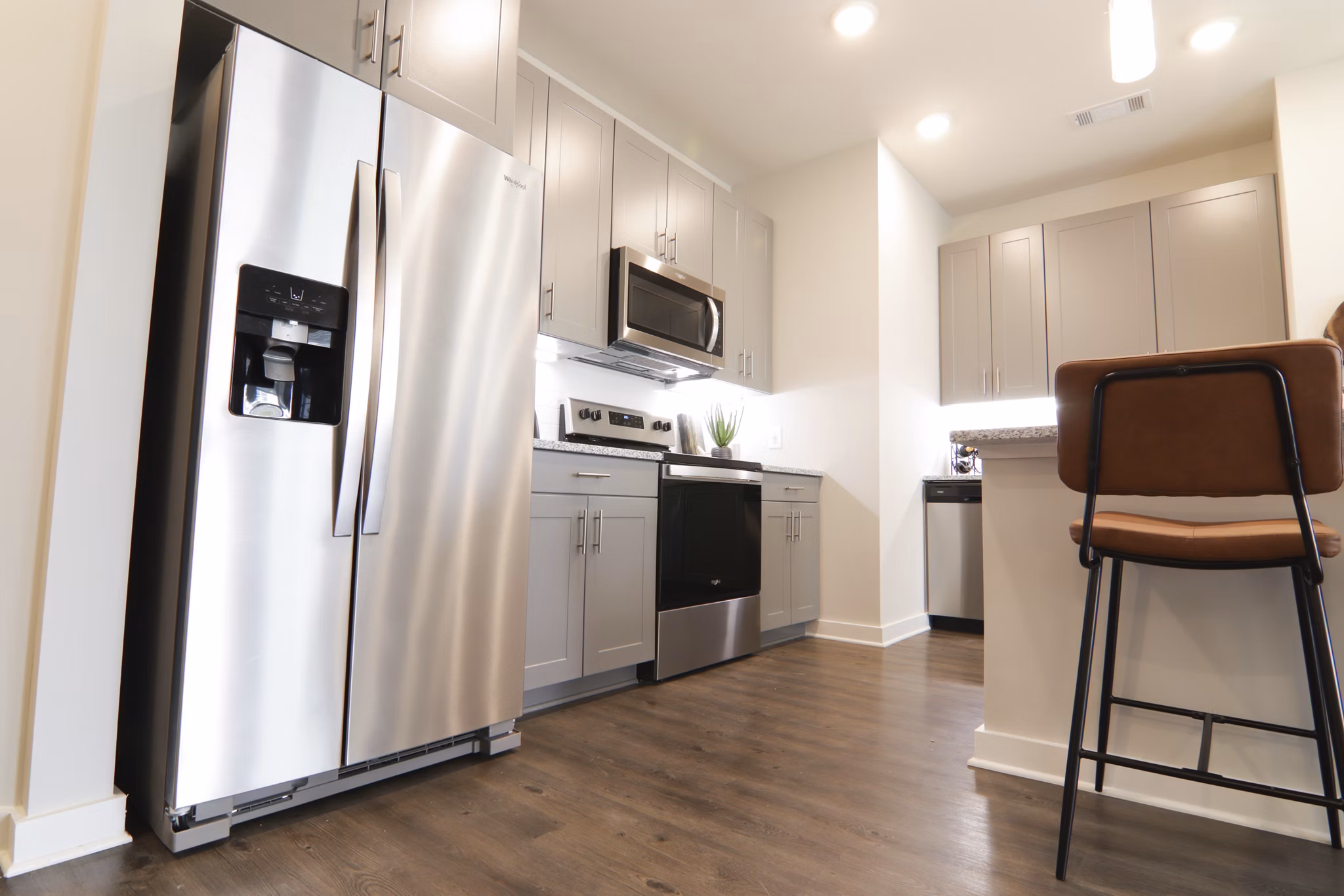 Modern kitchen with stainless steel appliances and granite countertops at The Ravelle at Ridgeview Apartments, luxury living in Greystar community