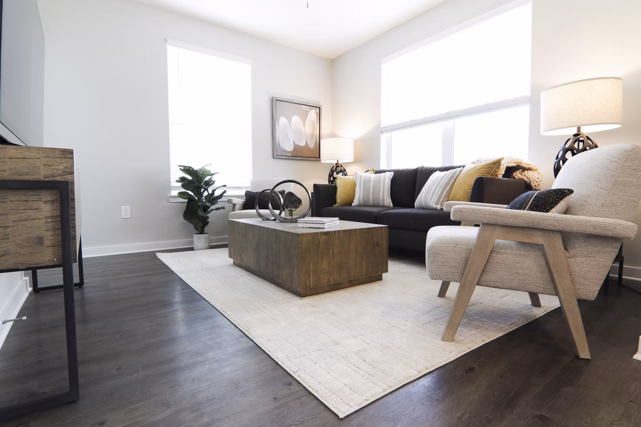Living room with modern decor and large windows at The Ravelle at Ridgeview Apartments