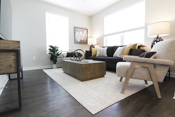 Living room with modern decor and large windows at The Ravelle at Ridgeview Apartments