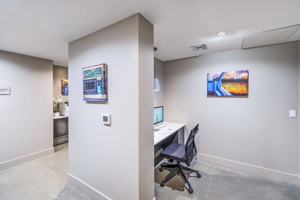 Modern clubhouse business center with sleek workstations at Alcove Apartments