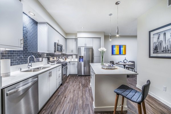 Modern kitchen with stainless steel appliances and quartz countertops at Alcove Apartments, a Greystar luxury apartment community