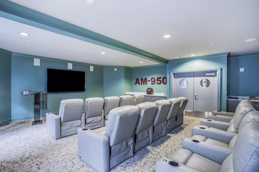 Clubhouse theater with plush seating and large screen at Everleigh Cool Springs Apartments