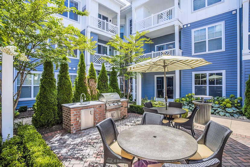 Outdoor grill area with modern patio furniture at Everleigh Cool Springs Apartments