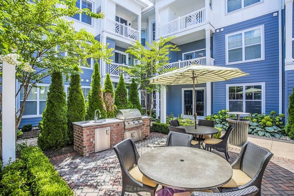 Outdoor grill area with modern patio furniture at Everleigh Cool Springs Apartments