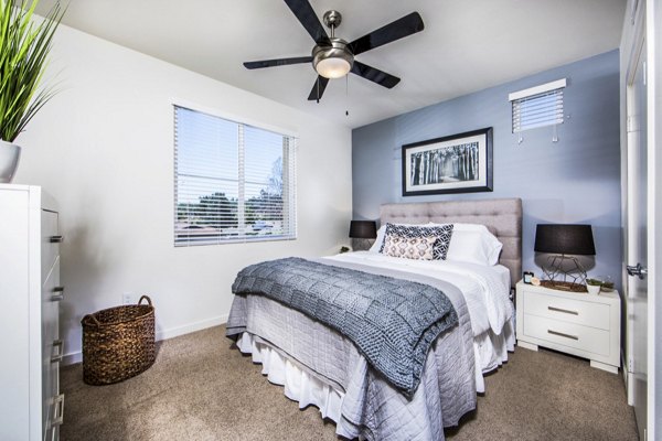 Haven76 Apartments: Modern bedroom with plush bedding and large window offering natural light