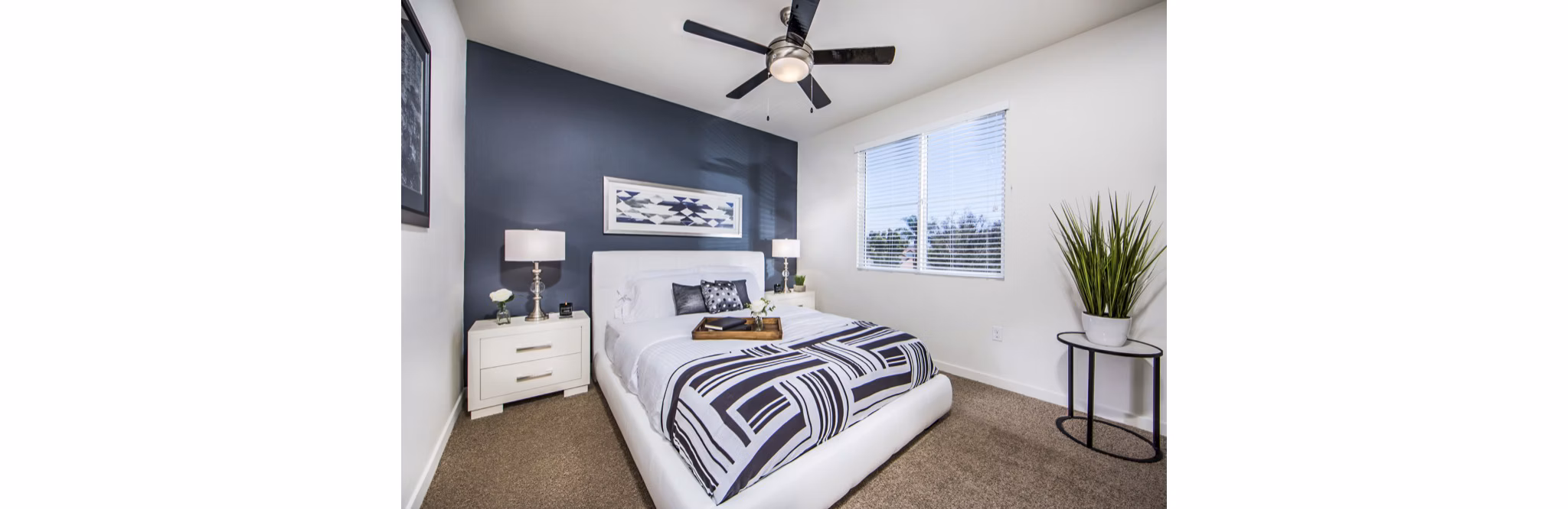 Cozy bedroom with modern decor at Haven76 Apartments, featuring ample natural light and sleek furnishings