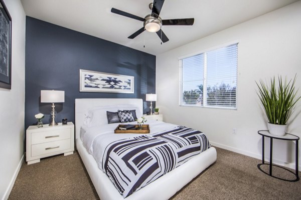 Cozy bedroom with modern decor at Haven76 Apartments, featuring ample natural light and sleek furnishings