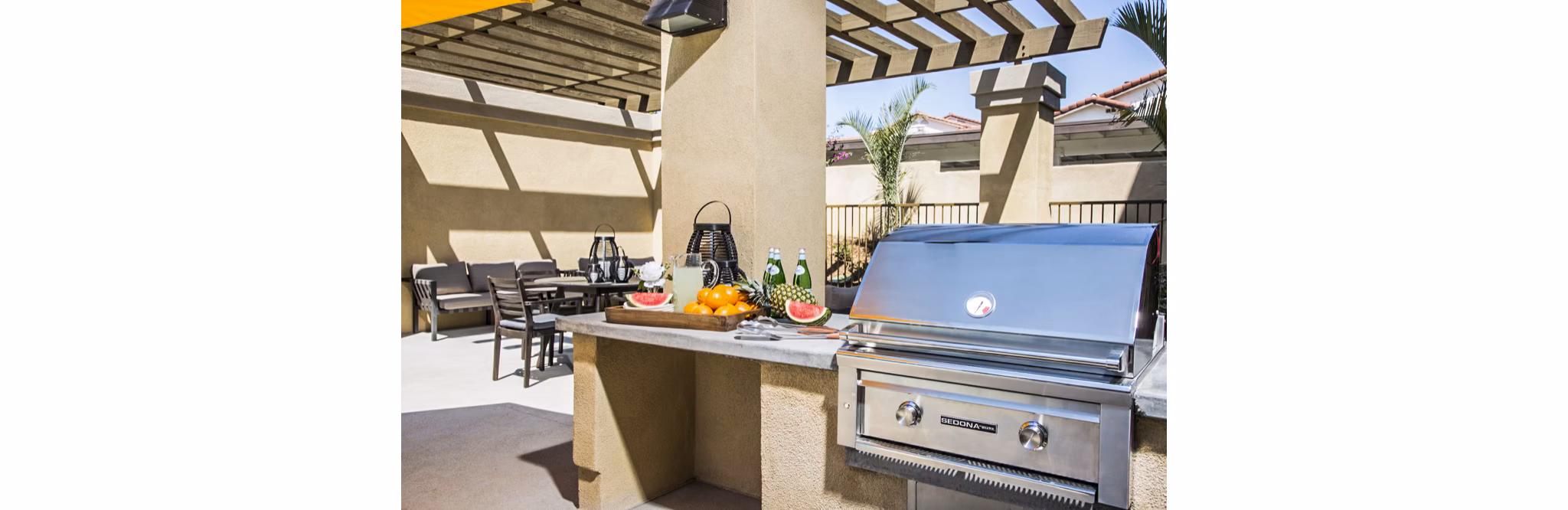 Outdoor grill area with cozy lounge seating on the patio at Haven76 Apartments