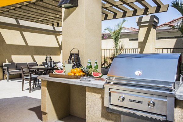 Outdoor grill area with cozy lounge seating on the patio at Haven76 Apartments
