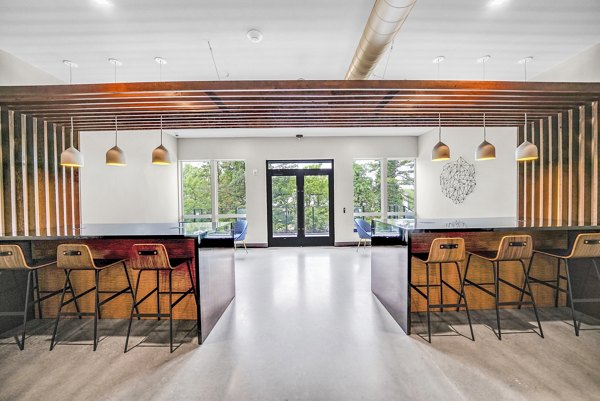 Modern clubhouse with lounge seating and billiards at Beckon Collective Apartments, Greystar luxury living community