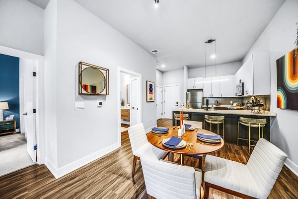 Dining area with modern furnishings and elegant lighting at Beckon Collective Apartments, offering luxurious living spaces in a vibrant community