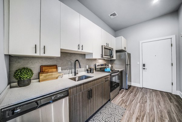 Modern kitchen with stainless steel appliances in Beckon Collective Apartments