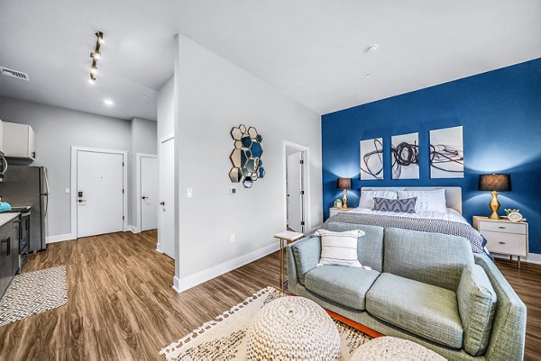 Studio living area and bedroom with contemporary decor at Beckon Collective Apartments