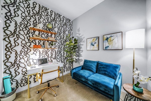 Bedroom with dedicated home office space at Beckon Collective Apartments, featuring sleek desk and large window for a bright work environment