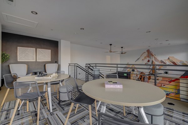 Modern clubhouse featuring lounge seating and a communal table at 644 City Station Apartments, an upscale living community