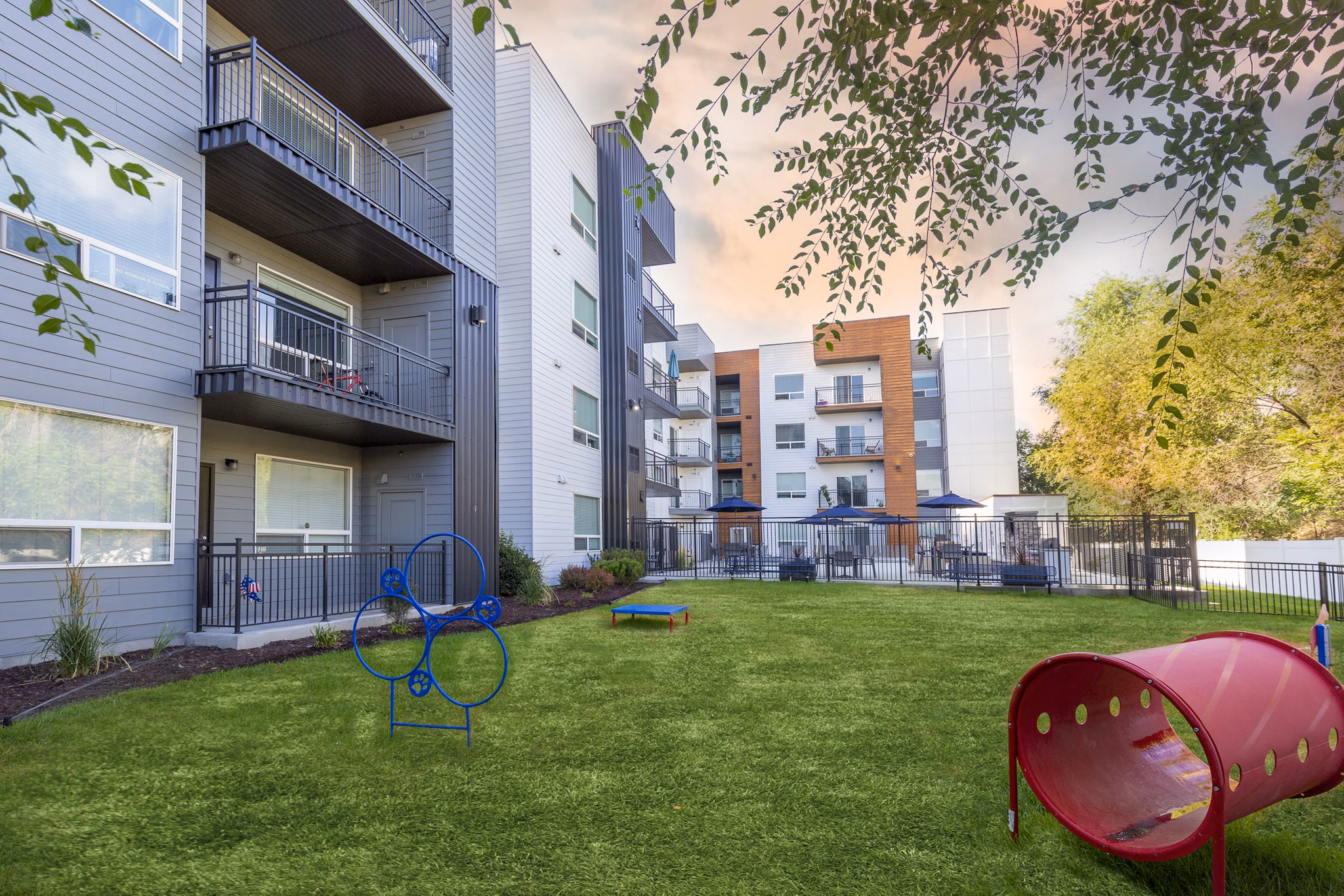 Dog park at 644 City Station Apartments: Spacious outdoor play area for pets featuring agility equipment and lush landscaping