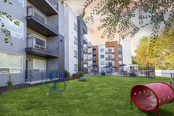 Dog park at 644 City Station Apartments: Spacious outdoor play area for pets featuring agility equipment and lush landscaping