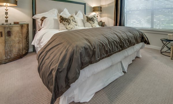Modern bedroom with plush bedding and city views at 2900 West Dallas Apartments