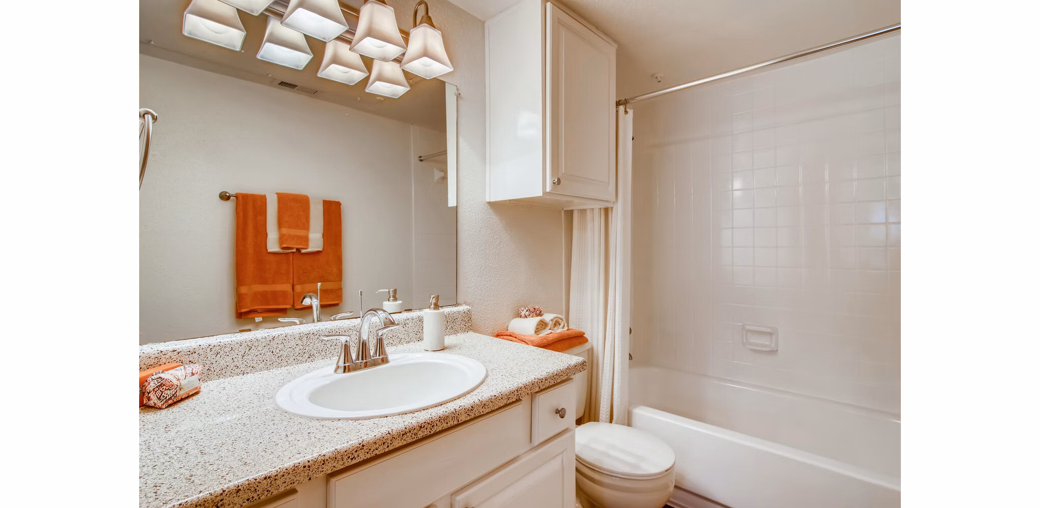 Modern bathroom with marble countertops and glass shower in The Bellfort Apartments, offering luxury living and stylish design