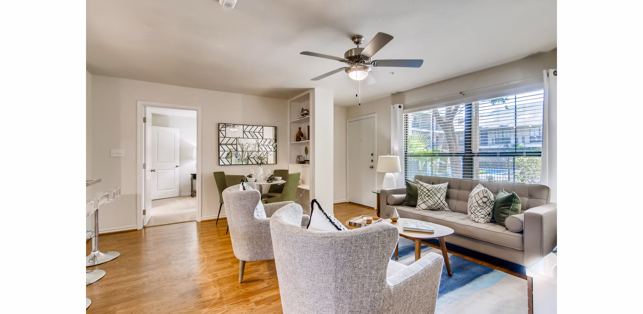 Spacious living room with modern decor at The Bellfort Apartments, featuring plush seating and ample natural light