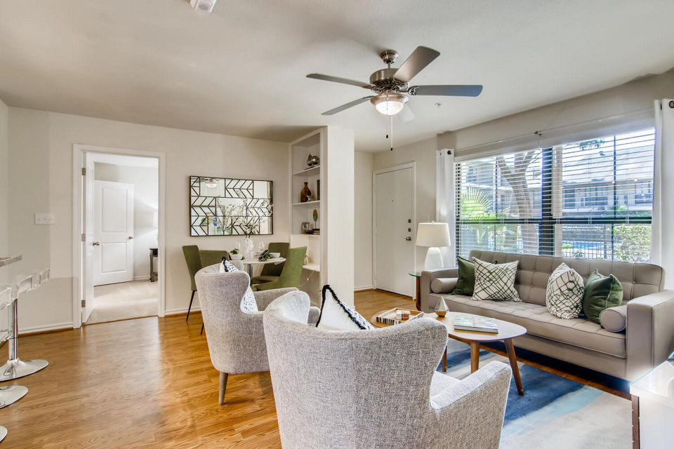 Spacious living room with modern decor at The Bellfort Apartments, featuring plush seating and ample natural light