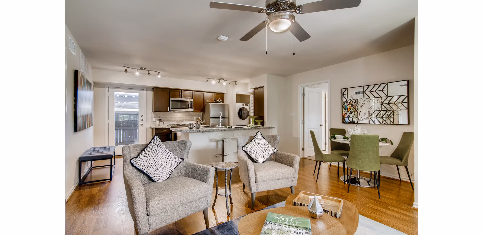 Modern living room featuring stylish decor and ample natural light at The Bellfort Apartments