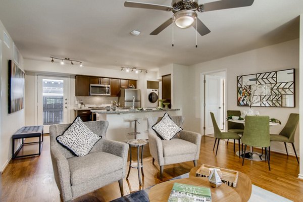 Modern living room featuring stylish decor and ample natural light at The Bellfort Apartments