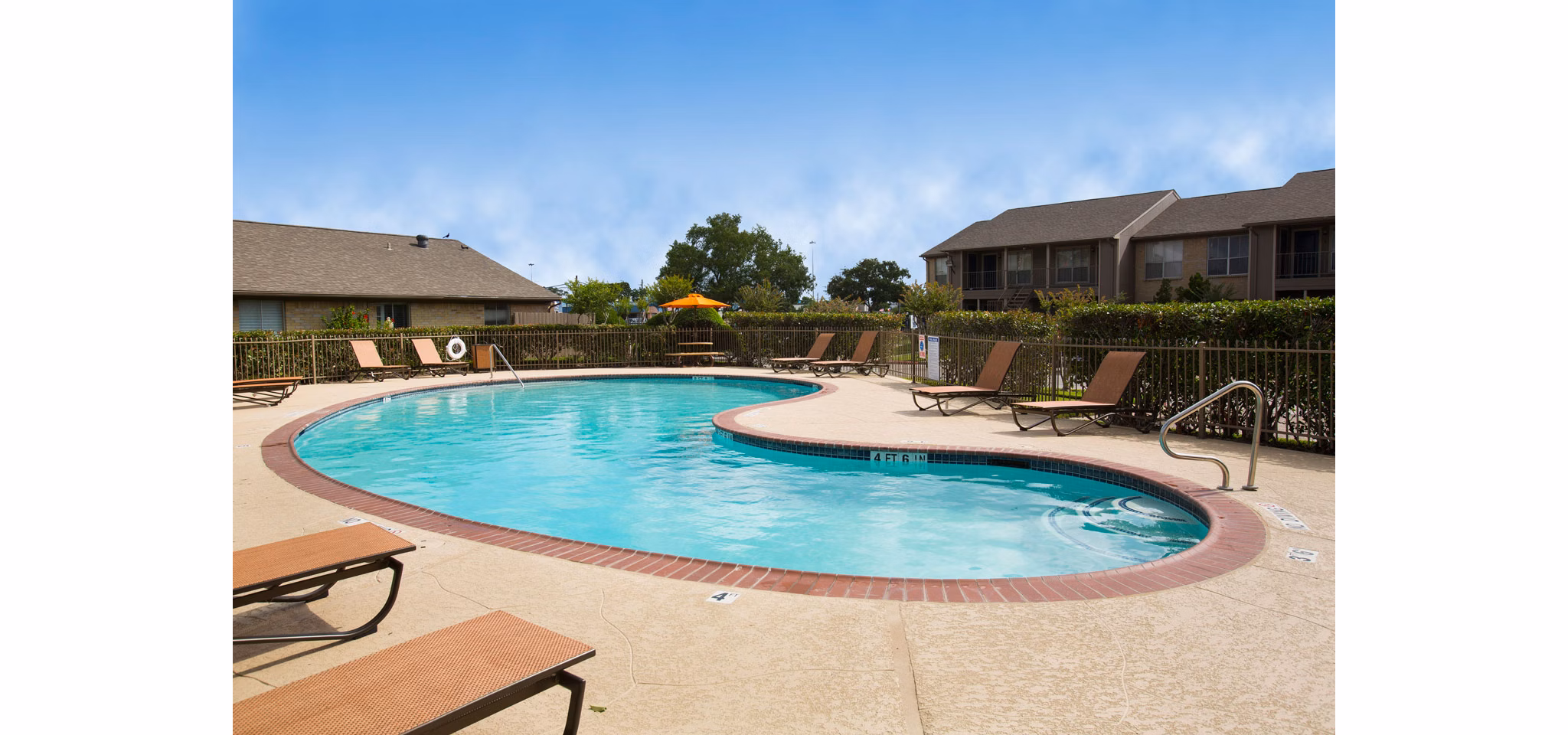 Poolside relaxation at The Bellfort Apartments with modern lounge chairs and shaded cabanas