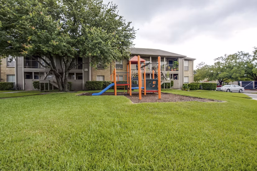 Colorful playground with slides and swings at The Bellfort Apartments featuring family-friendly outdoor spaces