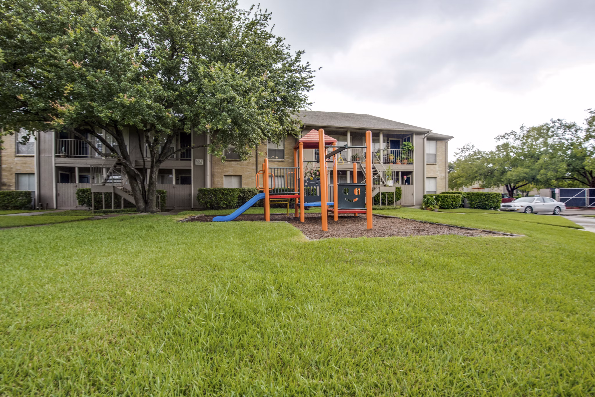Colorful playground with slides and swings at The Bellfort Apartments featuring family-friendly outdoor spaces