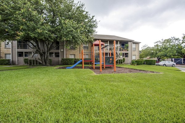 Colorful playground with slides and swings at The Bellfort Apartments featuring family-friendly outdoor spaces