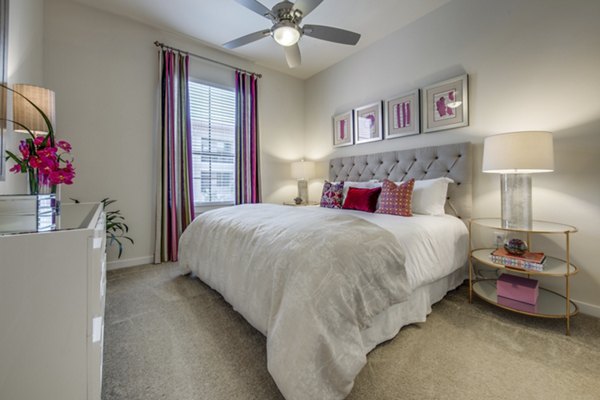 Cozy bedroom featuring plush bedding and modern decor at Grove at Wilcrest Apartments