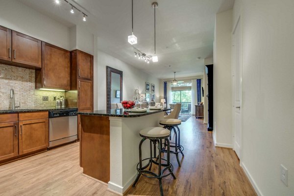Modern kitchen with stainless steel appliances at Grove at Wilcrest Apartments