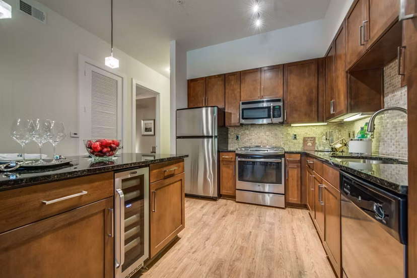 Modern kitchen with sleek countertops and stainless steel appliances at Grove at Wilcrest Apartments